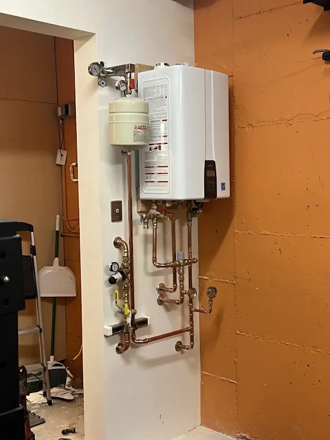 Plumbing technician inspecting water heater connections in Rosenberg